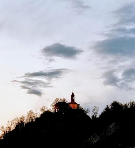 a building on top of a hill with a sky at Casa Rossa - Sweet Harmony in Castellinaldo