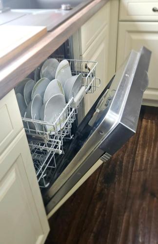 an open dishwasher filled with dishes in a kitchen at Tobi's Eifelhaus (1-6 Personen) in Kreuzau