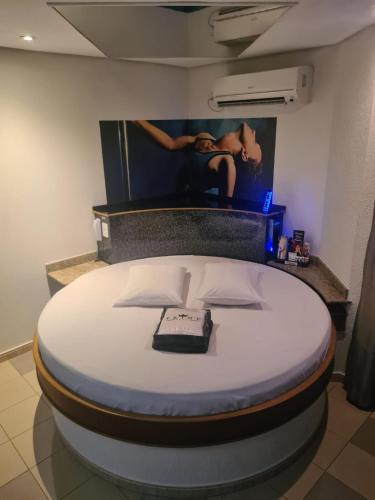 a large bed in a room with a picture on the wall at Prime Motel Americana in Americana