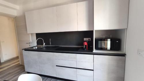 a kitchen with white cabinets and a microwave at The View 2 in Teglio