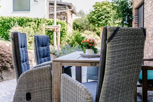 a wooden table with wicker chairs on a patio at Tobi's Eifelhaus (1-6 Personen) in Kreuzau
