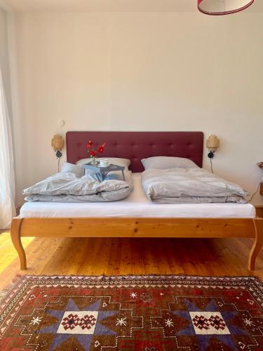 a bed with a wooden frame in a room at Seeblick mit Charme in der Villa Hirschfisch in Sattendorf