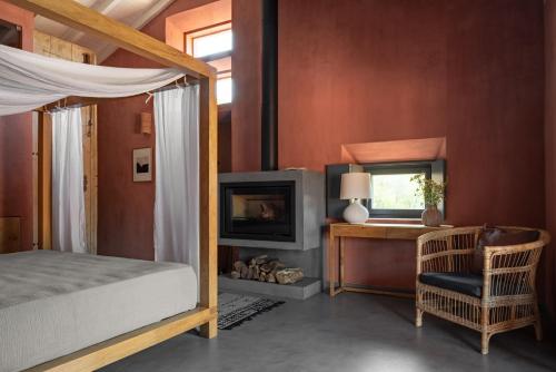 ein Schlafzimmer mit einem Bett, einem Schreibtisch und einem Fernseher in der Unterkunft Vale Palheiro Earth Resort - Soft Opening in Aljezur