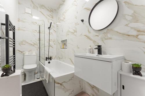 a white bathroom with a sink and a mirror at Ground Floor 3BR Parking King Bd in Kimberworth