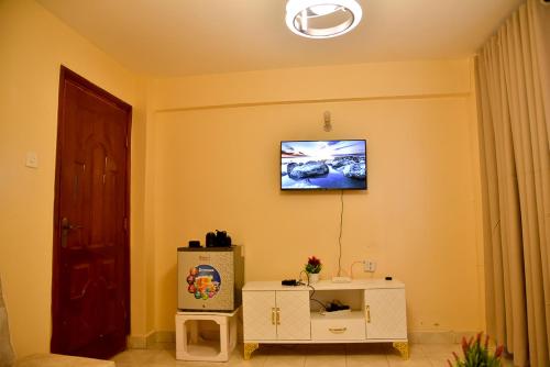 un salon avec une télévision au mur dans l'établissement Smart 1BR Apartment in Meru Fast Wi-Fi Near Kinoru Stadium, à Gatunga