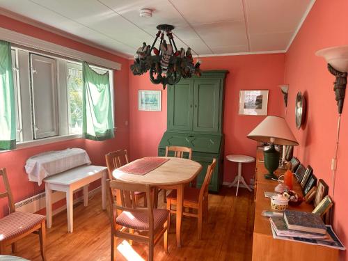 a dining room with red walls and a table and chairs at Asleep in the Valley Villa in Oslo