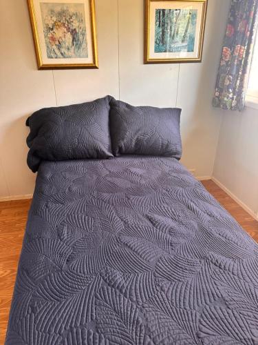 a bed with a purple comforter and two pillows at Asleep in the Valley Villa in Oslo