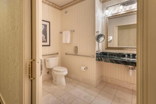 a bathroom with a toilet and a sink and a mirror at Omni San Francisco in San Francisco