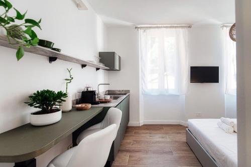 a kitchen with a counter and chairs in a room at Casa Batèl Suites & Apartments - By Breva Collections in Como