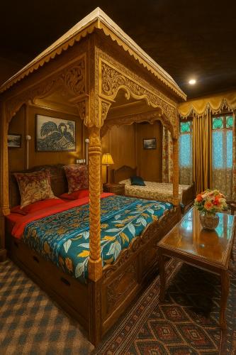 a bedroom with a canopy bed and a table at Crown Of India Group Of Houseboats in Srinagar