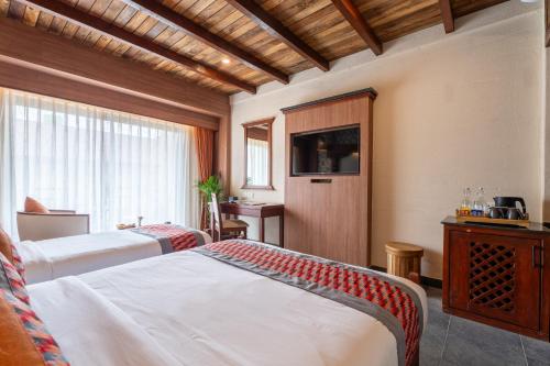 a hotel room with two beds and a window at Temple Bell Boutique Hotel & Spa in Pokhara