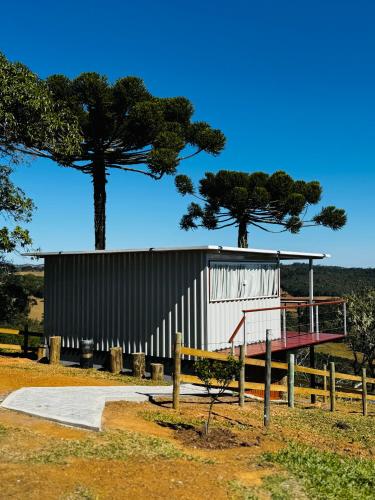 a building with a basketball hoop and two trees at Cabana Teixeira in Cunha