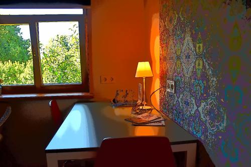 a table with a lamp on it next to a window at Pilava in Roja