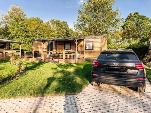 a car parked in front of a log cabin at Zeehuisje Naija in Renesse