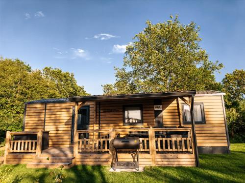 a log cabin with a porch and a deck at Zeehuisje Naija in Renesse