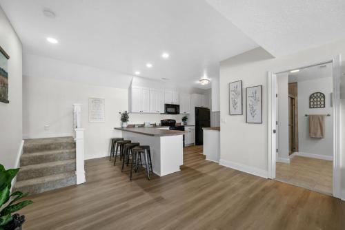 a kitchen and living room with white walls and wood floors at Bluebird Sanctuary w Stunning Sunset Views Sleeps 28 in Big Sandy