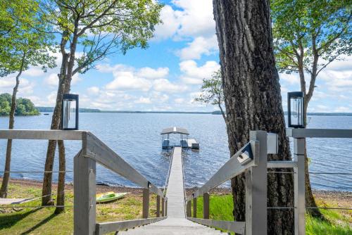 a wooden gate leading to a dock on a lake at Bluebird Sanctuary w Stunning Sunset Views Sleeps 28 in Big Sandy