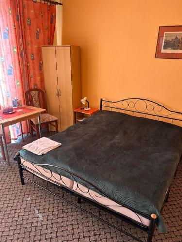 a bedroom with a bed and a table and a cabinet at Penzion Iga in Jindrichuv Hradec