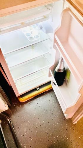 an open refrigerator with its door open and a drawer at Apart T 0 Studio or Flat Style in Downtown in Luanda