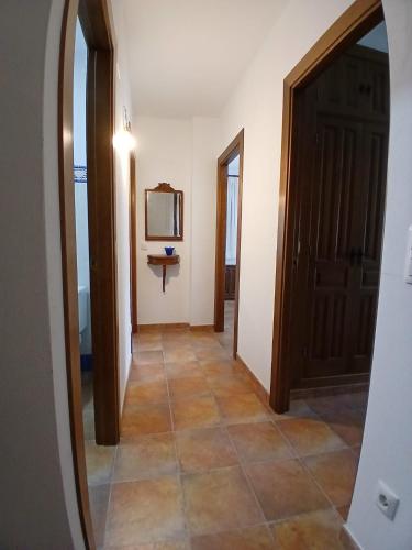 a hallway with a mirror and a door and a television at Encanto del Gregorio in Huerta del Marquesado