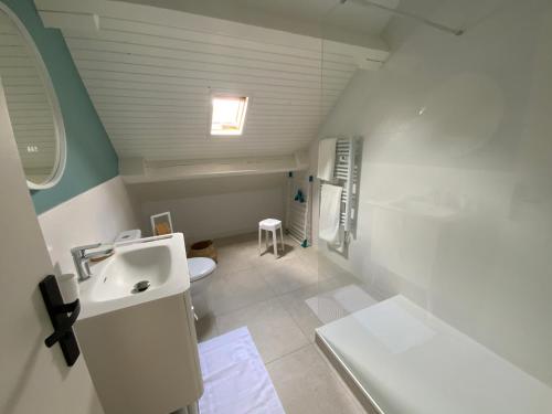 Un baño blanco con lavabo e inodoro. en Maison Saint Marc sur Mer, en Saint-Nazaire