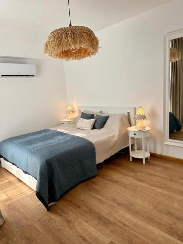 a bedroom with a large bed and a chandelier at Гнездото l The Nest in Burgas City