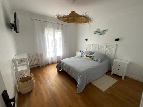 Un dormitorio con una cama y un ventilador. en Maison Saint Marc sur Mer, en Saint-Nazaire