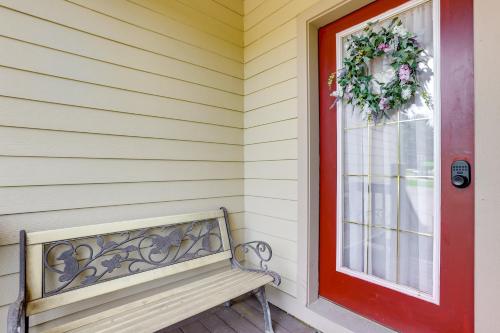 a bench in front of a house with a red door at Less Than Half-Mi to Lake Townhome with Hot Tub in McHenry! in McHenry