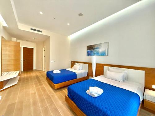 two beds in a hotel room with blue sheets at Condo Studio Plaza in Budva