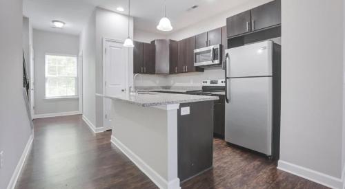 eine Küche mit einem weißen Kühlschrank und einer Arbeitsplatte in der Unterkunft Upscale King 3BR Townhouse Pineville in Charlotte