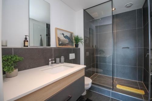 une salle de bain avec un lavabo et une douche dans l'établissement The Bridgewater Collection 409-Luxury 2 bed Modern Apartment at Century City, au Cap