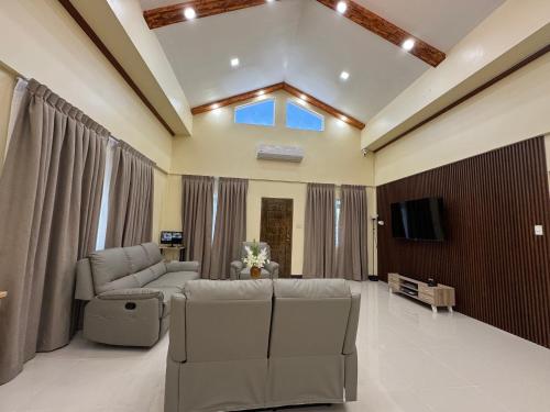 a living room with a couch and a tv at International Haven Barili in Barili