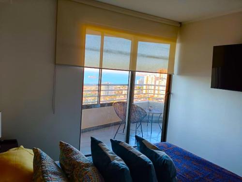 a bedroom with a bed and a large window with a view at Departamento con una hermosa vista al mar in Valparaíso