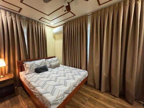 a bedroom with a large bed with curtains at International Haven Barili in Barili
