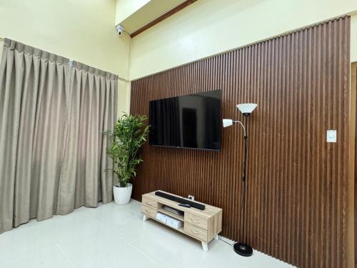 a living room with a tv on a wooden wall at International Haven Barili in Barili