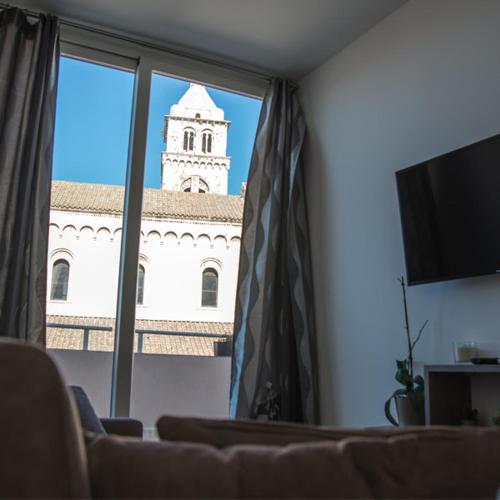 a view of a building with a clock tower through a window at Brezza Marina by Paolo in Barletta
