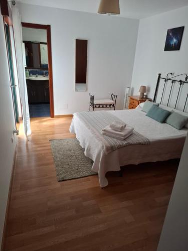 a bedroom with a bed and a wooden floor at Piso DJC in O Pedrouzo
