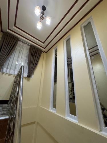 a room with two windows and a staircase at International Haven Barili in Barili