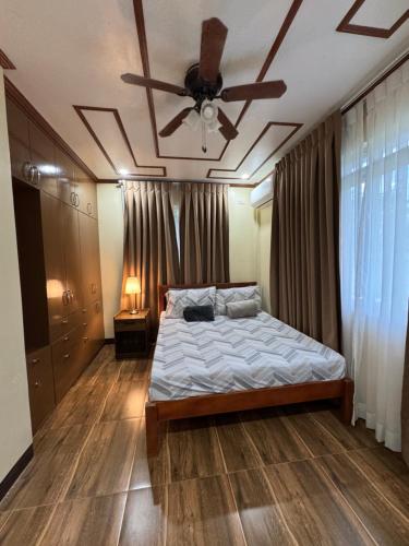 a bedroom with a bed with a ceiling fan at International Haven Barili in Barili