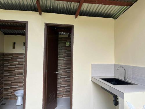 a bathroom with a sink and a toilet in a room at International Haven Barili in Barili