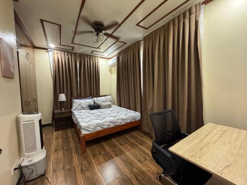 a bedroom with a bed and a desk and a table at International Haven Barili in Barili