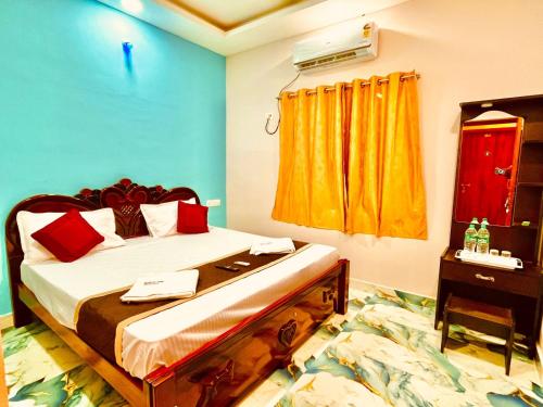 Un dormitorio con una cama con almohadas rojas y una ventana. en Nikilan Residency, en Rameswaram