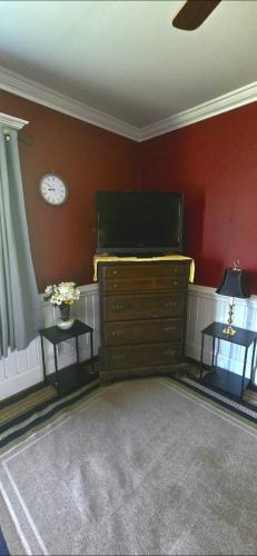 a room with a dresser and a clock on the wall at Room Rentals at Tenady in Greer
