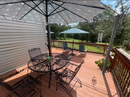 a patio with a table and chairs under an umbrella at Room Rentals at Tenady in Greer