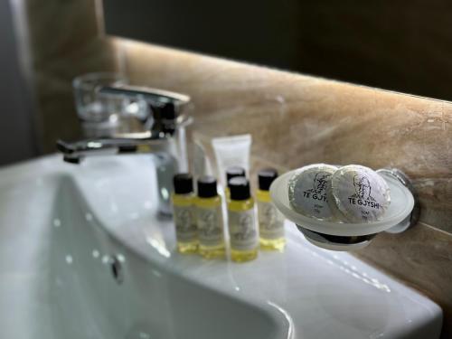 a bathroom sink with two bottles of disinfectants on it at Te Gjyshi in Berat