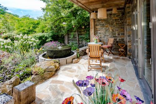 a patio with a fountain and chairs and flowers at Mijn-Habitat in Valkenburg