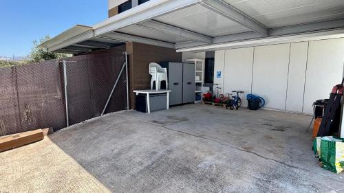 a garage with a fence and a table and chairs at Tu Paraíso Privado Con Piscina in Albolote