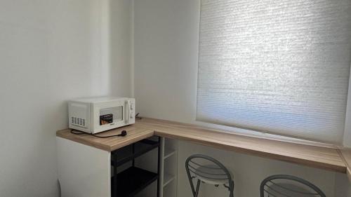 a microwave sitting on a table next to a window at Tu Paraíso Privado Con Piscina in Albolote