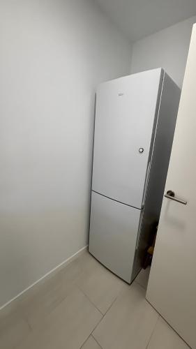 a white refrigerator in a room with a wall at Tu Paraíso Privado Con Piscina in Albolote