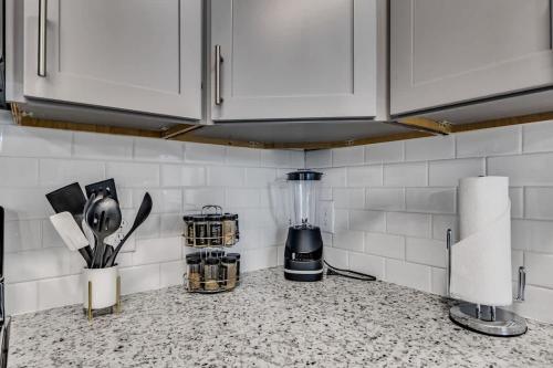 ダーラムにあるLuxe King 2BR Suite Mins to Downtown Durhamの白いキャビネットとミキサー付きのキッチンカウンター
